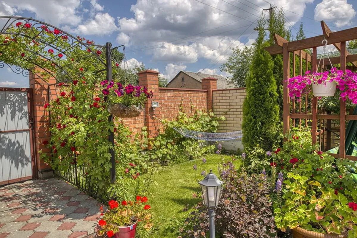 Зона отдыха среди цветов во дворе дома.