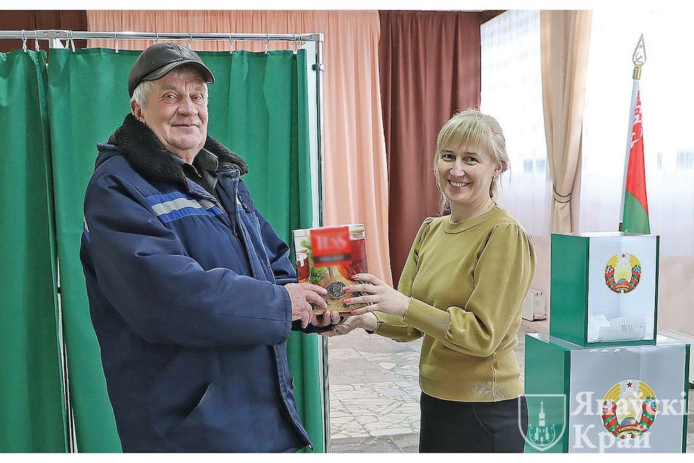 Вручение подарка избирателю членом комиссии на избирательном участке № 25 в агррородке Одрижин Ивановского района. Фото: janow.by.