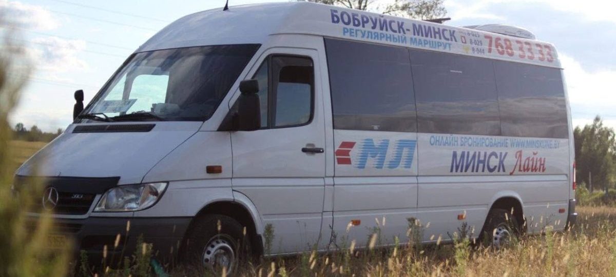 маршрутное такси белого цвета в поле